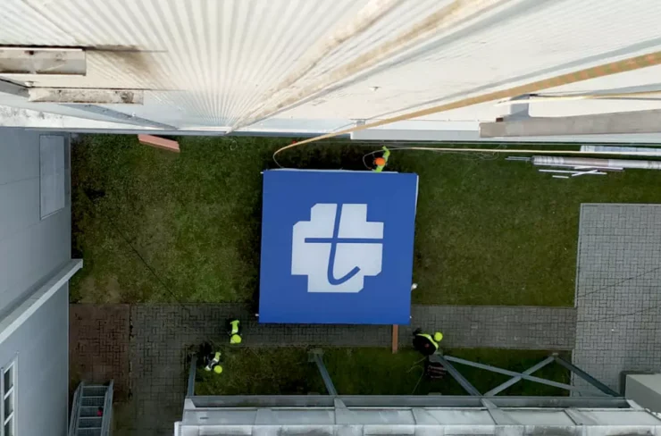 Ekipa montażowa Graffico trzymająca logo na trawniku