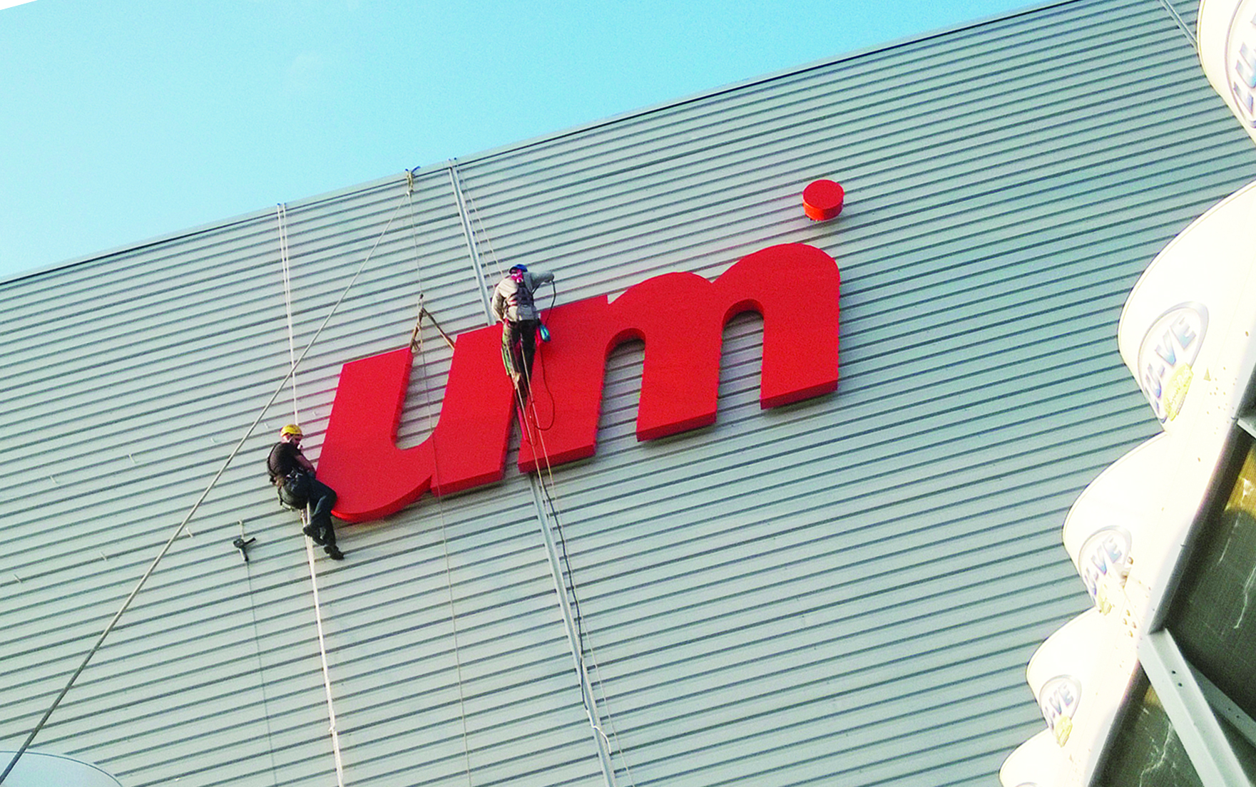 montażyści przy pracy nad literami na elewacji